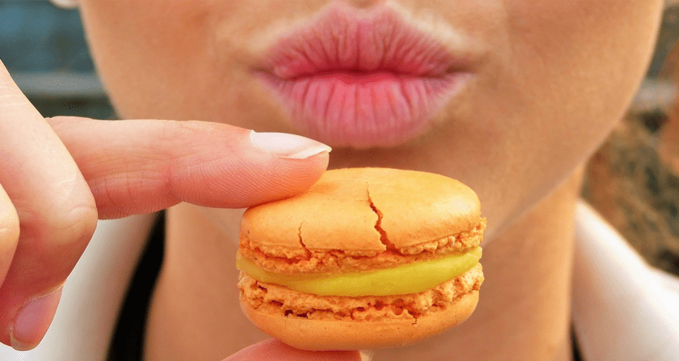 an orange cookie in front of lips